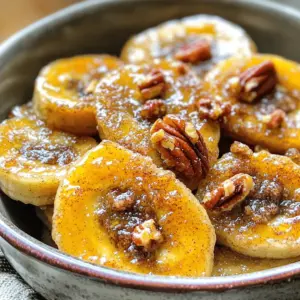 - 2 ripe but firm bananas - 2 tablespoons unsalted butter - 2 tablespoons brown sugar - 1 teaspoon ground cinnamon - Pinch of salt - 1 tablespoon honey (optional) - Chopped pecans or walnuts for garnish (optional) To make pan-fried cinnamon bananas, start with ripe bananas. Ripe bananas are sweet and soft but still firm enough to slice. You need two tablespoons of unsalted butter. Butter adds rich flavor and helps with browning. Next, grab two tablespoons of brown sugar. Brown sugar caramelizes well, giving the bananas a nice glaze. You will also need one teaspoon of ground cinnamon for warmth and spice. A pinch of salt enhances all the flavors. If you want extra sweetness, you can add one tablespoon of honey. Lastly, for garnish, chopped pecans or walnuts add crunch and nutrients. - Calories per serving: Approximately 150 - Macronutrient breakdown: - Carbohydrates: 24g - Protein: 1g - Fat: 6g This dish is not only tasty, but it also provides energy from the bananas and sugar. - For alternative sweeteners, try maple syrup or coconut sugar. - If you need dairy-free options, use coconut oil instead of butter. These swaps keep the flavor while catering to different diets. Feel free to experiment with what you have! To start, you need to slice the bananas correctly. First, take two ripe but firm bananas. Place them on a cutting board. Use a sharp knife to cut them into ½ inch rounds. This size helps them cook evenly and caramelize well. Next, we need to melt the butter efficiently. In a large skillet, add 2 tablespoons of unsalted butter. Turn the heat to medium. Watch it closely until it starts to foam. This means it’s ready for the bananas. Now, let’s cook the bananas. Add the sliced bananas to the skillet in a single layer. Avoid overcrowding them to ensure even cooking. Cook for 1-2 minutes on one side. You want them to start caramelizing. For flipping bananas without breaking, use a spatula. Gently lift a banana slice and turn it over. Be careful not to press down too hard. Once flipped, sprinkle 2 tablespoons of brown sugar, 1 teaspoon of ground cinnamon, and a pinch of salt over them. Cook for another 1-2 minutes until the sugar dissolves and coats the bananas. To achieve the perfect syrup consistency, watch the bananas closely. The mixture should become thick and sticky. If you like extra sweetness, drizzle 1 tablespoon of honey over the bananas during the last minute of cooking. For presentation, serve the cinnamon bananas warm in a bowl. Drizzle any remaining syrup from the skillet over the top. You can add chopped pecans or walnuts for extra crunch. Enjoy them on their own or with a scoop of vanilla ice cream for a treat! To keep your bananas intact, slice them into ½-inch rounds. This size helps them hold their shape as they cook. Avoid overcrowding the skillet. Cook in batches if needed. Giving each banana space allows for even cooking and caramelization. Adjust the heat as you cook. Start with medium heat to melt the butter. If you notice the bananas browning too fast, lower the heat. This way, they cook slowly and soak up all the sweet flavors. These bananas shine when paired with ice cream or yogurt. The creaminess balances the warm, sweet bananas. You can also layer them in a parfait. Add granola, yogurt, and bananas for a fun breakfast treat. For an extra touch, serve them with a drizzle of honey on top. This adds sweetness and makes the dish look beautiful. Spices can take your dish to the next level. Think about adding a pinch of nutmeg or allspice. These spices mix well with cinnamon and add depth. For texture, consider adding chopped nuts. Pecans or walnuts add a nice crunch. Sprinkle them on top just before serving. This adds flavor and makes the dish more exciting. You can find the Full Recipe to try these tips and tricks! {{image_2}} You can easily change the flavors of pan-fried bananas. Add a splash of vanilla extract while cooking. This small change adds a sweet and rich aroma. You might also try other spices. A hint of nutmeg can bring warmth to the dish. It pairs well with cinnamon and makes the flavors pop. Bananas are great, but you can mix in other fruits too. Apples and peaches work nicely with bananas. Slice them thin and add them to the skillet. This creates a colorful and tasty mixed fruit medley. The different textures and flavors will surprise your taste buds. If you want a vegan option, simply swap butter for coconut oil. It gives a nice flavor and keeps the dish plant-based. You can also skip the honey if you prefer. For gluten-free serving ideas, this dish is already gluten-free. Just enjoy it as is, or serve it with gluten-free options like yogurt. Check out the Full Recipe for more details on how to prepare this treat! To keep your pan-fried cinnamon bananas fresh, store them in an airtight container. Place them in the fridge. They stay good for about 2 days. After that, they may become mushy and lose their taste. You can reheat your leftovers in two ways: the microwave or on the stove. If you use the microwave, heat them for about 20-30 seconds. Check them often to avoid overheating. For the stove, use a non-stick skillet over low heat. This keeps them from getting too soft. Stir gently while heating to bring back some of the original texture. Can you freeze pan-fried bananas? Yes, you can! However, they may change texture. To freeze, place the cooled bananas in a single layer on a baking sheet. Freeze them for about 1-2 hours, then transfer them to a freezer bag. When you're ready to eat, thaw them in the fridge overnight. For quicker thawing, you can leave them out at room temperature for about 30 minutes. How do you know when bananas are ripe enough to use? You want bananas that are yellow with some brown spots. This shows they are sweet. Avoid green bananas; they are too firm. Overripe bananas may be too mushy for frying. Can I make these bananas ahead of time? It is best to cook them fresh. They taste best when warm. If you prepare them in advance, the texture will change. They may become soft and lose their syrupy finish. Can I use frozen bananas for this recipe? Frozen bananas can work, but they may be too mushy. If you use them, thaw and drain excess water. This helps keep some shape when frying. Fresh bananas are always a better choice. What if I don’t have brown sugar? You can use white sugar instead. Add a little maple syrup or honey for flavor. This can mimic the taste of brown sugar. You can also mix white sugar with a bit of molasses if you have it. What goes well with pan-fried cinnamon bananas? These bananas pair great with vanilla ice cream or yogurt. You can also serve them on pancakes or waffles. Chopped nuts add a nice crunch, too. Can I serve this dish for breakfast? Absolutely! Pan-fried cinnamon bananas make a great breakfast treat. They are quick to make and delicious. Serve them alongside eggs or toast for a full meal. This blog post covers all you need to create perfect pan-fried cinnamon bananas. We discussed ingredients, cooking steps, and variations to inspire your kitchen adventures. Remember, you can adjust ingredients for dietary needs. Also, try new flavors and serve them uniquely. With the tips and tricks shared, you can impress anyone with this simple dish. Enjoy exploring the delightful world of cooking with bananas. Your culinary journey starts here!