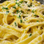- 8 oz fettuccine pasta - 3 tablespoons unsalted butter - 4 cloves garlic, minced - 1 cup heavy cream - 1 cup freshly grated Parmesan cheese - 1 teaspoon Italian seasoning - Salt and pepper to taste - Fresh parsley, chopped (for garnish) When picking your pasta, I love using fettuccine. It's thick and captures the sauce well. Unsalted butter gives you control over the salt in your dish. Freshly grated Parmesan melts better than pre-grated. For the garlic, fresh is always best. You want that strong flavor! The heavy cream is key for a rich sauce. If you want a lighter dish, you can swap it out for half-and-half. Just know it won't be as creamy. If you're gluten-free, try using gluten-free pasta. There are many good options available. For a dairy-free version, use a plant-based cream and cheese. Nutritional yeast can also give a cheesy flavor. If you want to cut fat, you can use low-fat cream. Adjust salt if needed, since some low-fat products have added salt. First, boil a large pot of salted water. Add 8 ounces of fettuccine pasta. Cook it according to the package instructions. Aim for al dente, which should take about 8 to 10 minutes. Once cooked, drain the pasta. Remember to save ½ cup of the pasta water for later. In a large skillet, melt 3 tablespoons of unsalted butter over medium heat. Add 4 minced garlic cloves. Sauté the garlic for 1 to 2 minutes. Be careful not to let it burn. Next, pour in 1 cup of heavy cream. Bring it to a gentle simmer. Cook for 3 to 4 minutes while stirring. This helps it thicken slightly. Lower the heat and whisk in 1 cup of freshly grated Parmesan cheese. Stir until it melts into a creamy sauce. Season with 1 teaspoon of Italian seasoning, salt, and pepper to taste. If the sauce is too thick, add some reserved pasta water until it reaches the right consistency. Now, add the cooked fettuccine to the skillet. Toss the pasta to coat it evenly with the garlic Parmesan sauce. Once mixed, remove from heat. Garnish with chopped fresh parsley for a pop of color. Serve the dish warm and enjoy! Garlic can turn bitter if overcooked. To keep its sweet taste, cook it on low heat. Sauté minced garlic for only 1-2 minutes. Watch it closely; once fragrant, it’s ready. Remove it from heat if you smell burning. This will keep your sauce bright and flavorful. To get that perfect creamy texture, start with cold heavy cream. Gradually add it to warm butter and garlic. This helps it blend well. Whisk in the Parmesan cheese slowly until it melts. If the sauce gets too thick, add some reserved pasta water. This keeps it smooth and easy to coat on pasta. Taste is key! Always sample your sauce before serving. If it needs more zing, add more salt, pepper, or Italian seasoning. Fresh parsley adds color and a fresh taste. You can also try red pepper flakes for a bit of heat. Adjust flavors to match your preference and enjoy! {{image_2}} You can easily add protein to your Garlic Parmesan Pasta. Here are some great choices: - Grilled chicken: Slice it and mix it in for a hearty meal. - Shrimp: Sauté shrimp in the garlic butter for a seafood twist. - Bacon: Crisp bacon bits add a nice crunch and flavor. Adding protein makes the dish filling and adds variety. For a vegetarian twist, skip the meat and keep the creamy sauce. To make it vegan: - Use plant-based butter instead of regular butter. - Swap heavy cream for coconut cream or cashew cream. - Choose nutritional yeast instead of Parmesan cheese for a cheesy taste. These changes keep the dish delicious while meeting dietary needs. You can enhance the flavor with simple additions. Consider these ideas: - Red pepper flakes: Add a bit for heat. - Spinach: Toss fresh spinach in for color and nutrients. - Mushrooms: Sauté mushrooms with garlic for an earthy flavor. Experimenting with flavors lets you customize your dish to your liking. To store your leftover garlic Parmesan pasta, let it cool first. Place it in an airtight container. This keeps it fresh for up to three days in the fridge. If you want to keep it longer, freezing is a good option. When you reheat the pasta, do it slowly. You can use a skillet or microwave. If using a skillet, add a splash of water or cream. Stir it until warm. For the microwave, heat in short bursts. Stir between each burst to avoid hot spots. If you want to freeze the pasta, use a freezer-safe container. Make sure to leave some space at the top. The pasta will expand when frozen. It can last up to two months in the freezer. To thaw, move it to the fridge overnight. Then, reheat as mentioned before. To boost flavor, add more garlic. Use six cloves instead of four. You can also mix in cooked bacon or sautéed mushrooms. Fresh herbs like basil or thyme add great taste, too. A squeeze of lemon juice brightens the dish. You might also try a pinch of red pepper flakes for heat. Yes, you can use any pasta shape you like. Penne, spaghetti, or even gluten-free pasta works well. Just remember to adjust the cooking time based on the pasta shape. Follow the package instructions for the best results. Each type brings a unique texture to the dish. Absolutely! Use gluten-free pasta made from rice or corn. The sauce stays the same. Just be sure to check the labels for any allergens. Cook the gluten-free pasta according to the package instructions. The flavor will still shine through, making it a great option for everyone. This blog post covered how to make a tasty Garlic Parmesan Pasta. We went through the important ingredients, cooking steps, and useful tips. You learned how to make the sauce creamy and adjust the flavors. I also shared variations to suit your taste and storage info for leftovers. Cooking is fun and simple. With these steps, you can impress anyone with this dish. Enjoy experimenting in your kitchen!
